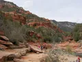 Natural red rock water slide along Oak Creek at Slide Rock State Park, Arizona, with canyon walls and lush streamside vegetation
