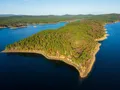Aerial drone view of Lake Ouachita's clear blue waters surrounded by forested Ouachita Mountain hills, Arkansas