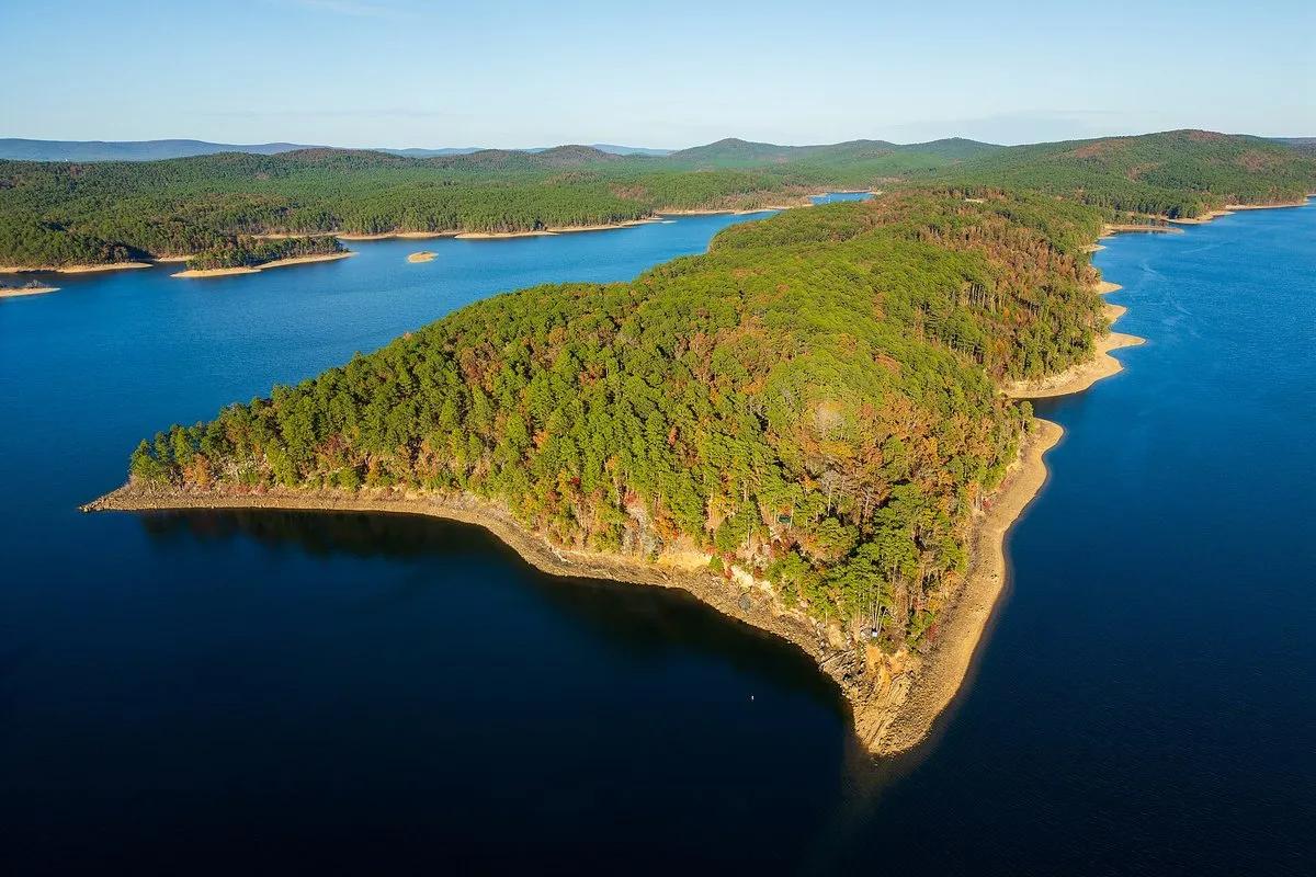 Aerial drone view of Lake Ouachita's clear blue waters surrounded by forested Ouachita Mountain hills, Arkansas