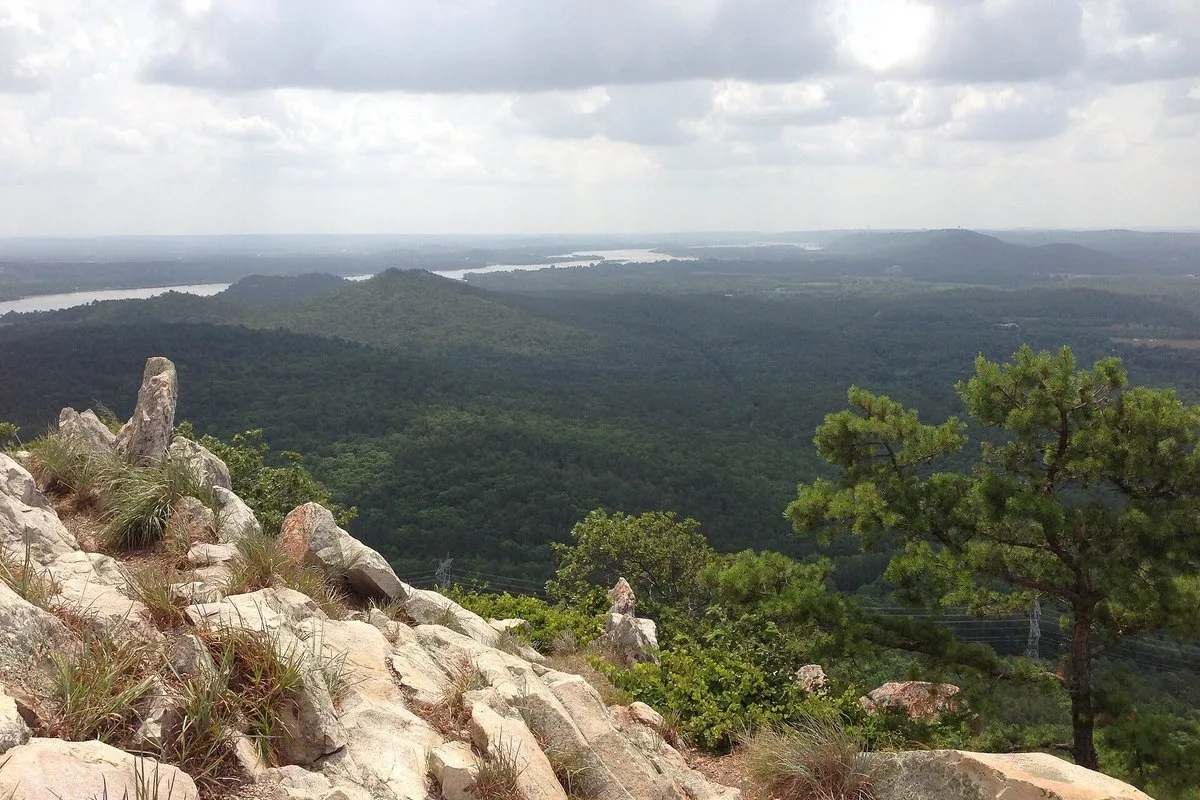 Scenic view of the cone-shaped summit of Pinnacle Mountain rising above green forest in Arkansas