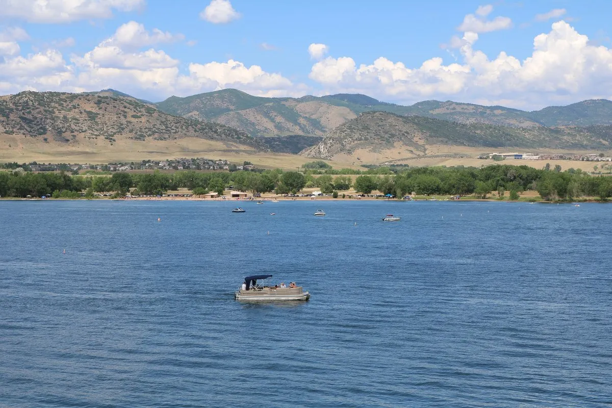 Scenic view of Chatfield Reservoir with open water, shoreline vegetation, and the Rocky Mountain foothills in the background
