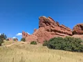 Dramatic red sandstone rock fins rising above green foothills at Roxborough State Park, Colorado