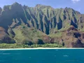 Scenic view of the rugged emerald sea cliffs of Napali Coast, Hawaii, rising above the deep blue Pacific Ocean