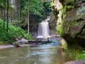 Scenic sandstone canyon with a cascading waterfall and lush green forest at Matthiessen State Park, Illinois