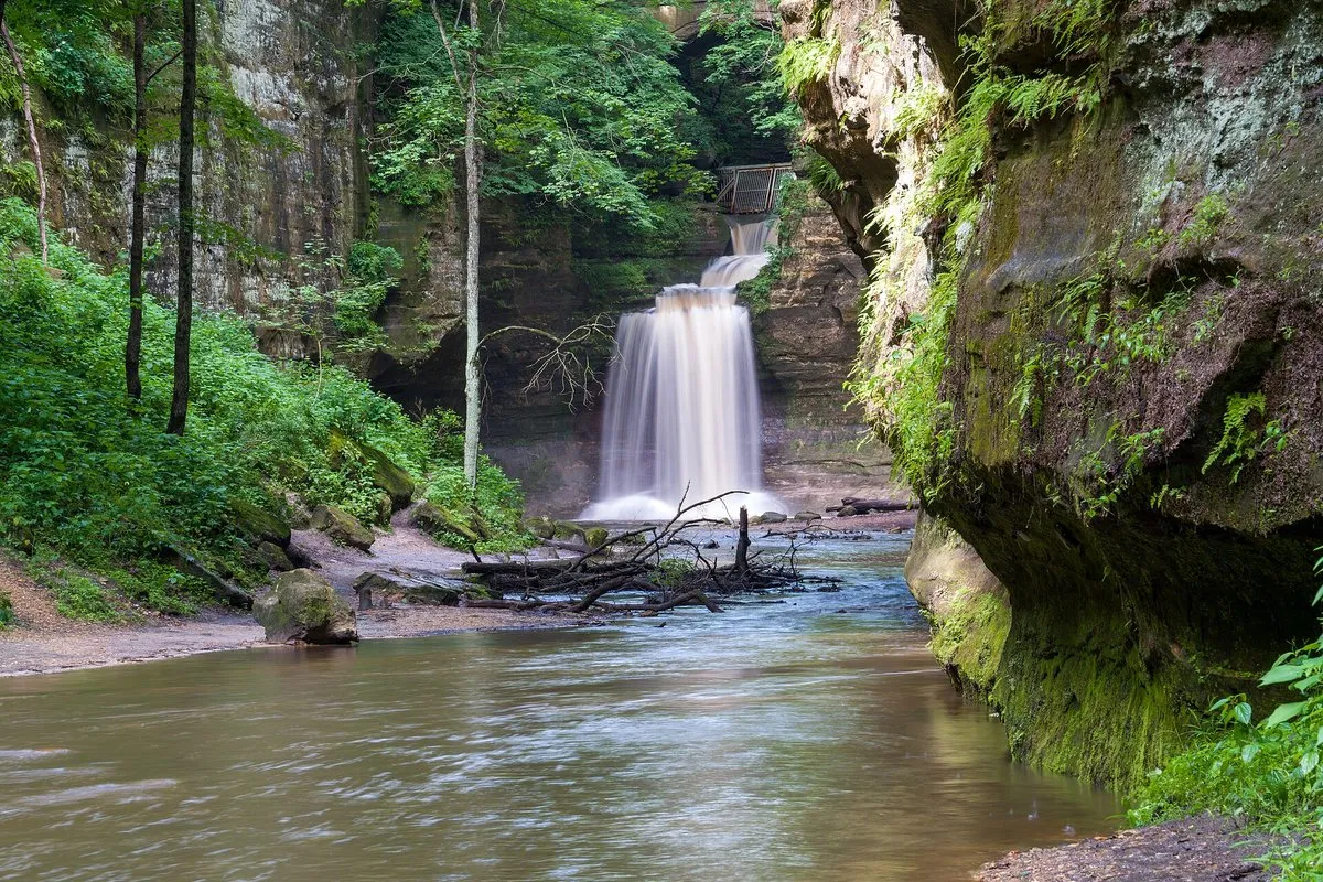 Scenic sandstone canyon with a cascading waterfall and lush green forest at Matthiessen State Park, Illinois