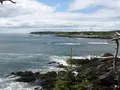 Scenic view of the red and white striped West Quoddy Head Lighthouse overlooking the rocky coastline at Quoddy Head State Park, Maine