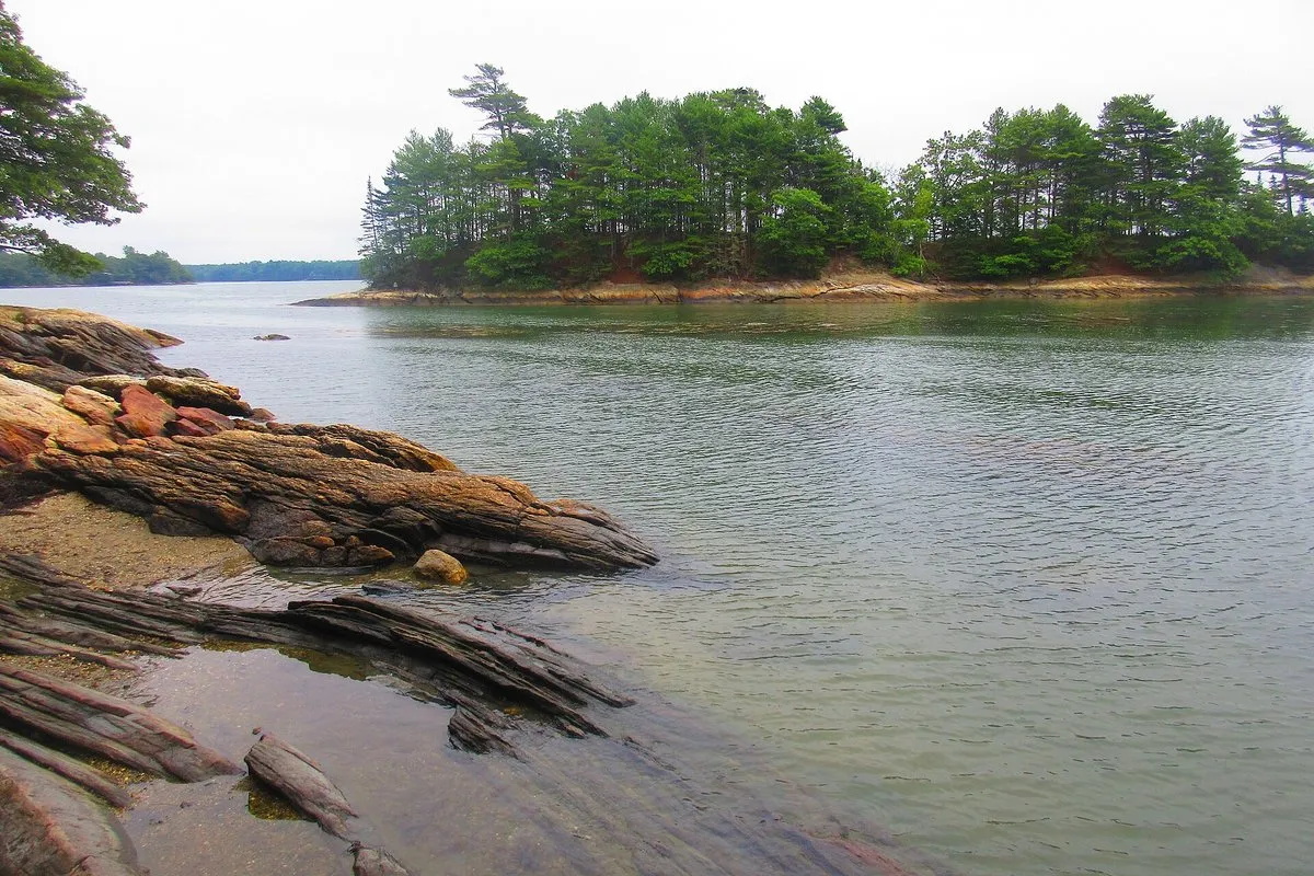 Scenic view at Wolfe's Neck Woods State Park, Maine, showing rocky coastline and forested shoreline along Casco Bay