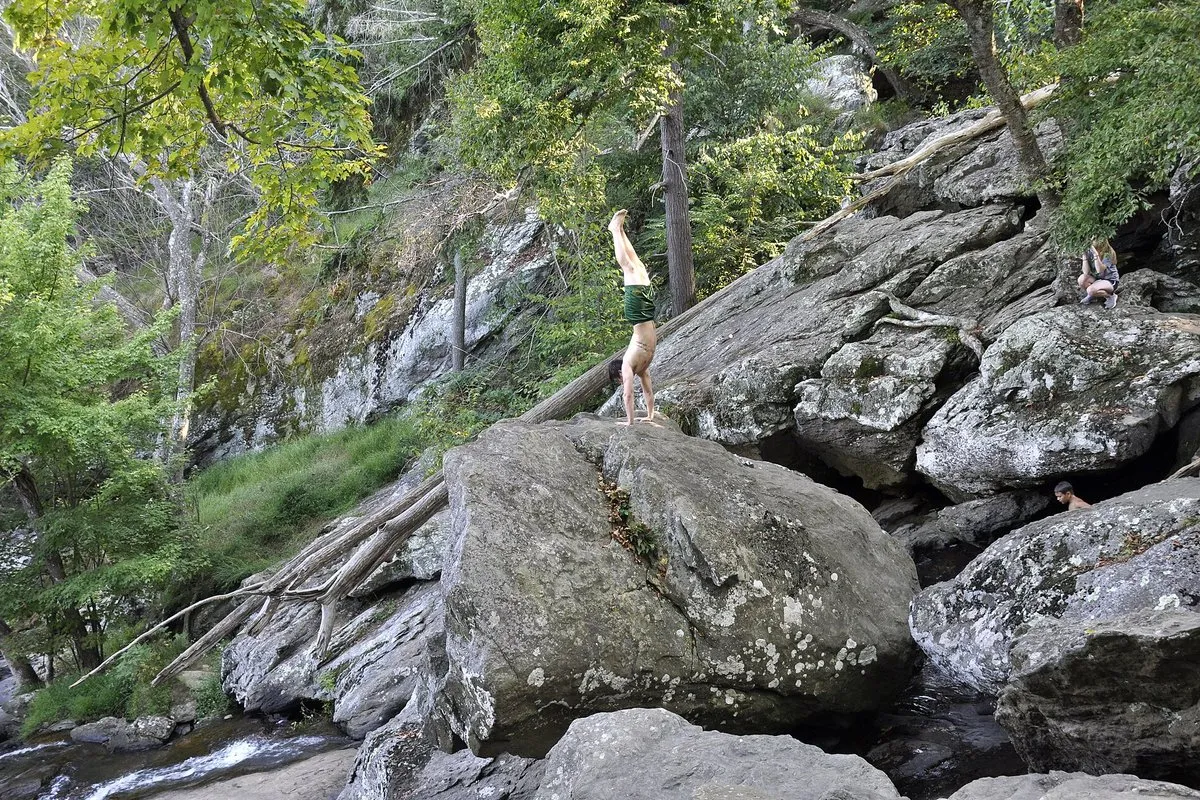 Scenic view of Cunningham Falls cascading over rocky ledges surrounded by lush forest in Maryland