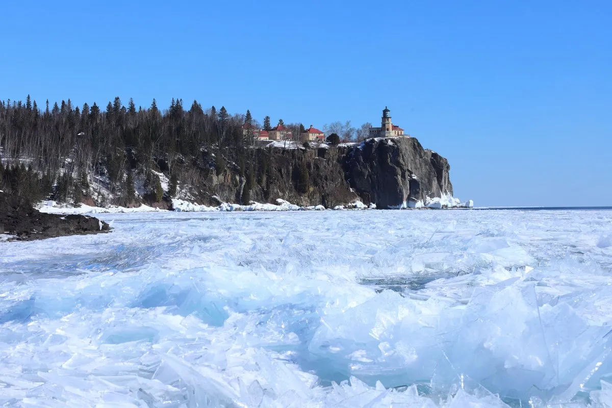 The historic Split Rock Lighthouse perched on a rocky cliff above the blue waters of Lake Superior, Minnesota