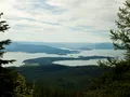 Scenic view of Flathead Lake, Montana, with calm blue water reflecting surrounding mountains and forested shoreline