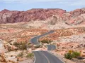 Sweeping view of vivid red sandstone rock formations under a blue sky at Valley of Fire, Nevada