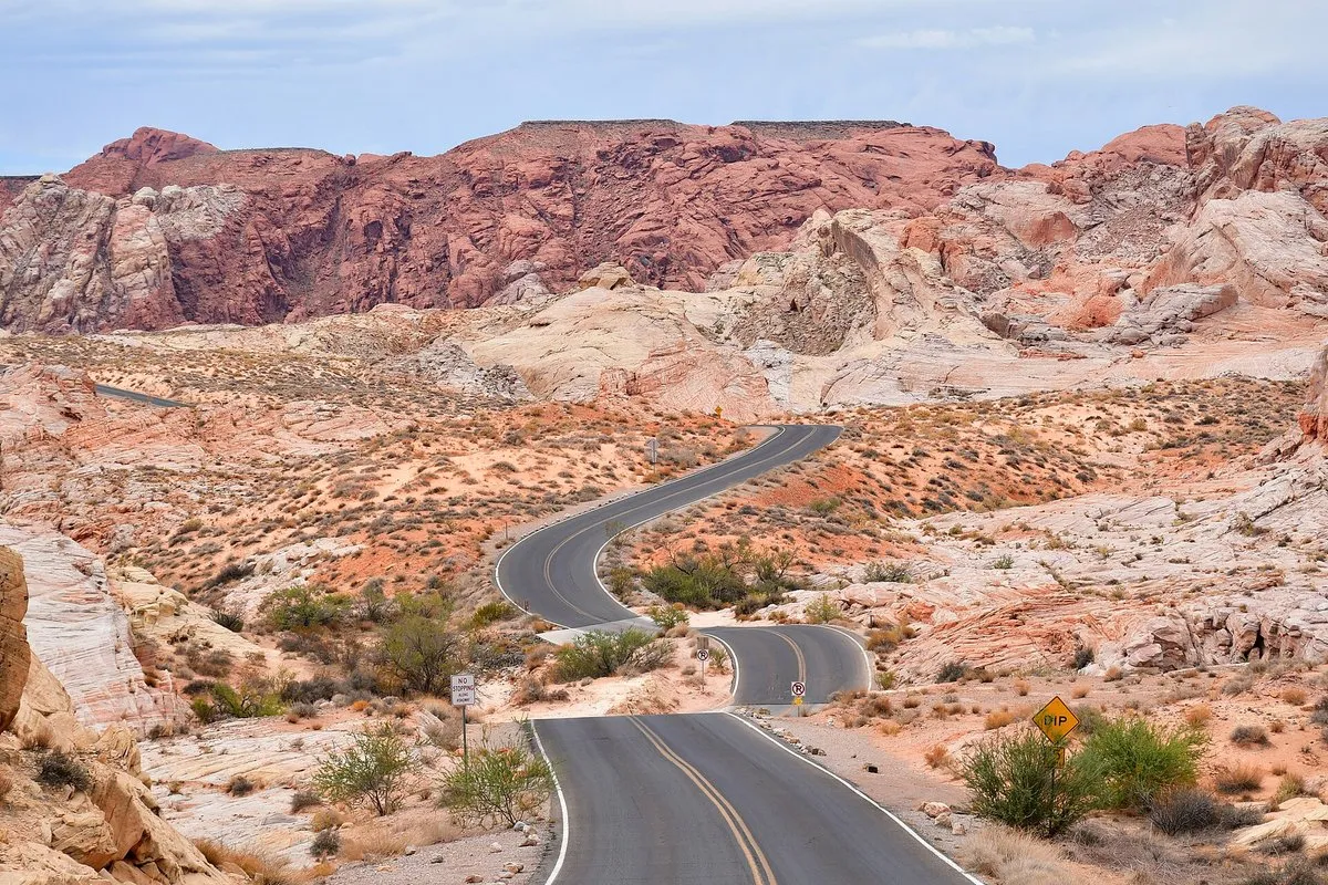 Sweeping view of vivid red sandstone rock formations under a blue sky at Valley of Fire, Nevada