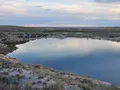 Vivid blue-green sinkhole lake nestled among red bluffs at Bottomless Lakes State Park, New Mexico