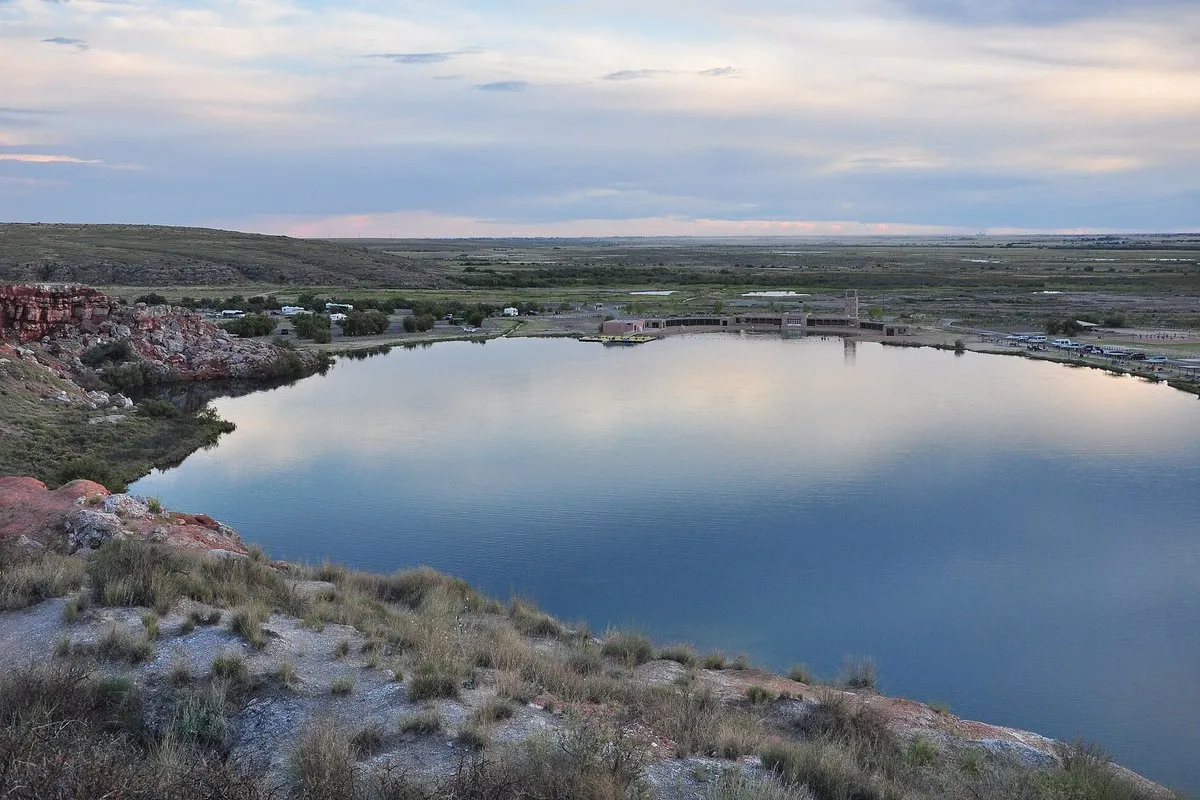 Vivid blue-green sinkhole lake nestled among red bluffs at Bottomless Lakes State Park, New Mexico