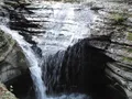 Scenic gorge trail winding past cascading waterfalls and mossy stone walls at Watkins Glen State Park, New York