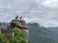 Scenic view of the towering Chimney Rock granite monolith rising above forested Blue Ridge Mountain slopes at Chimney Rock State Park, North Carolina