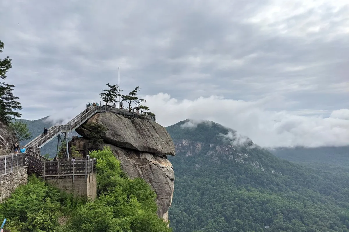 Scenic view of the towering Chimney Rock granite monolith rising above forested Blue Ridge Mountain slopes at Chimney Rock State Park, North Carolina