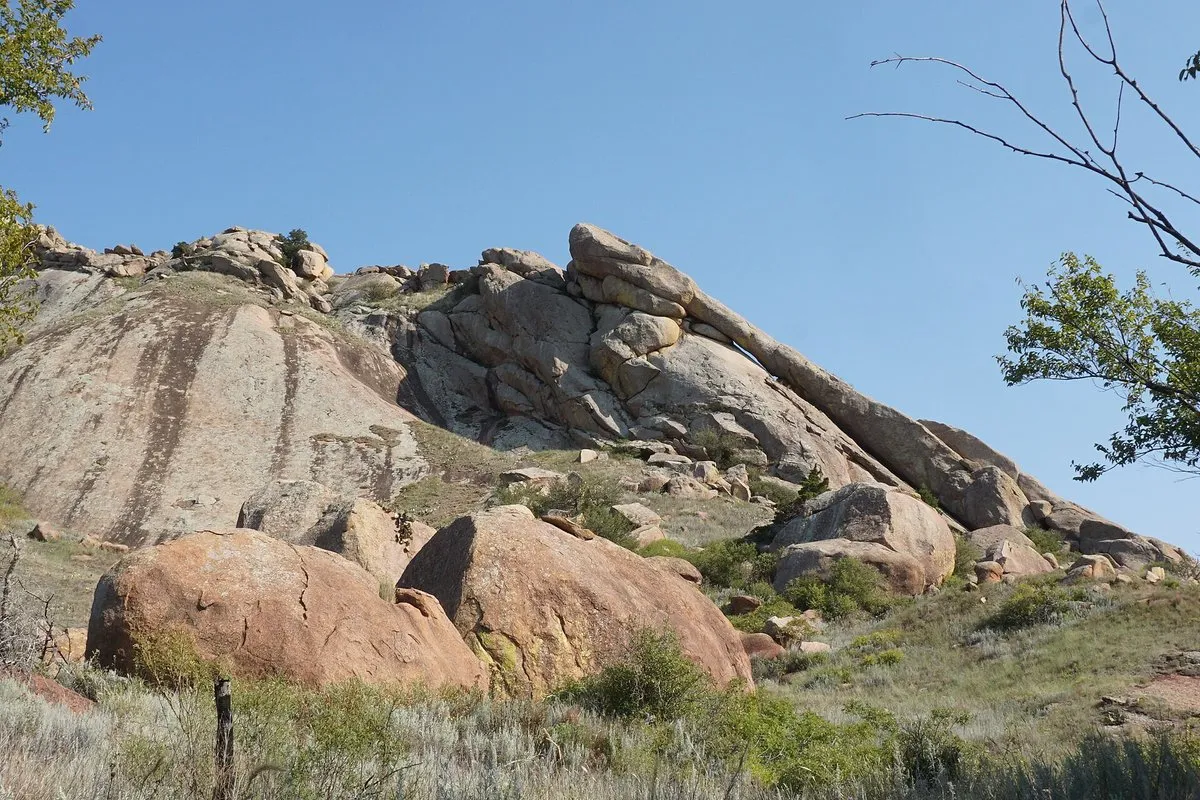 Scenic view at Quartz Mountain, Oklahoma, with rugged granite outcrops rising above the blue waters of Lake Altus-Lugert under a wide open sky