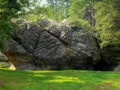 Rugged sandstone cave entrance surrounded by dense green forest at Robbers Cave, Oklahoma