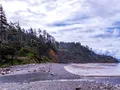 Scenic coastal view at Ecola State Park, Oregon, with rocky headlands, forested cliffs, and the Pacific Ocean stretching to the horizon