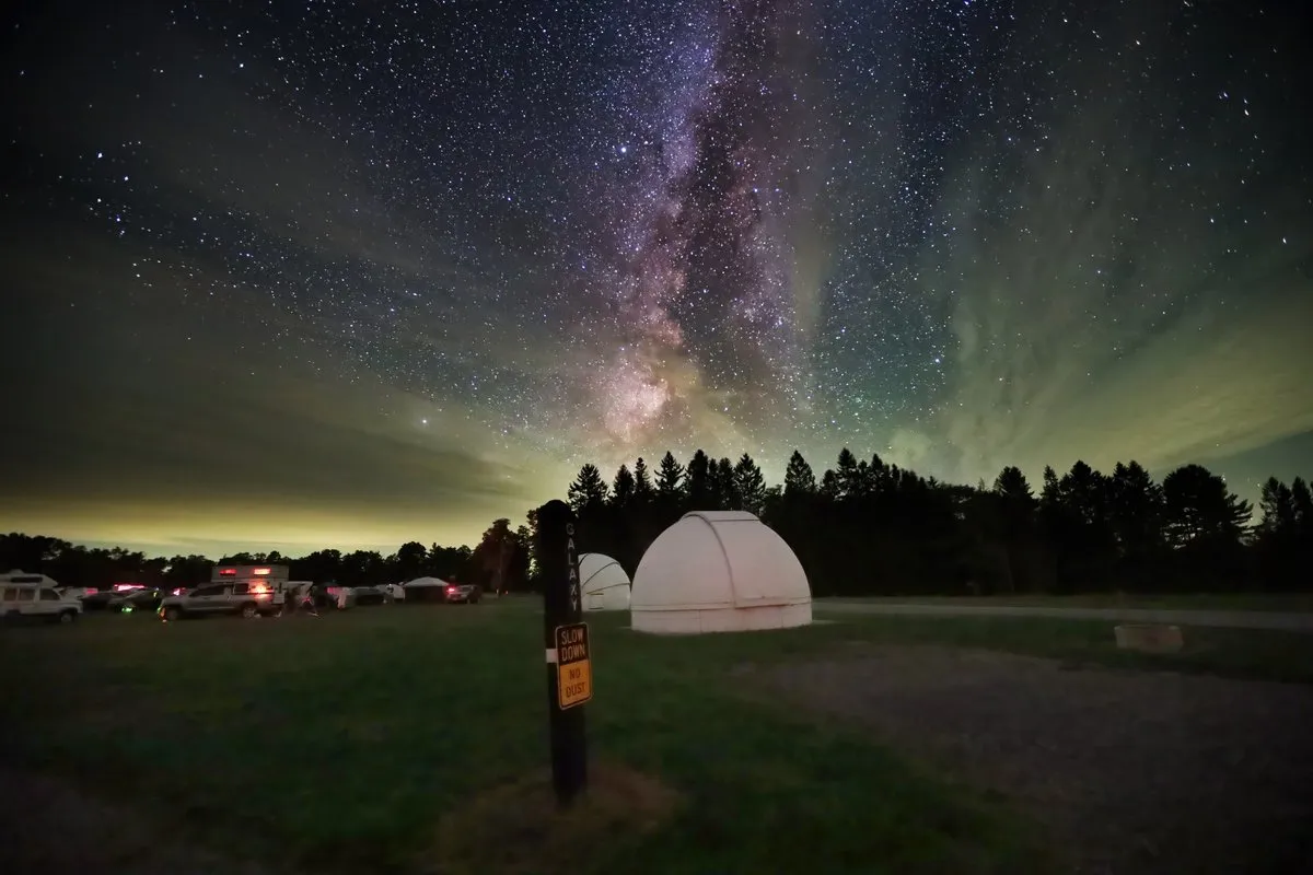 Night sky filled with stars and the Milky Way above the dark hilltop meadow at Cherry Springs State Park, Pennsylvania