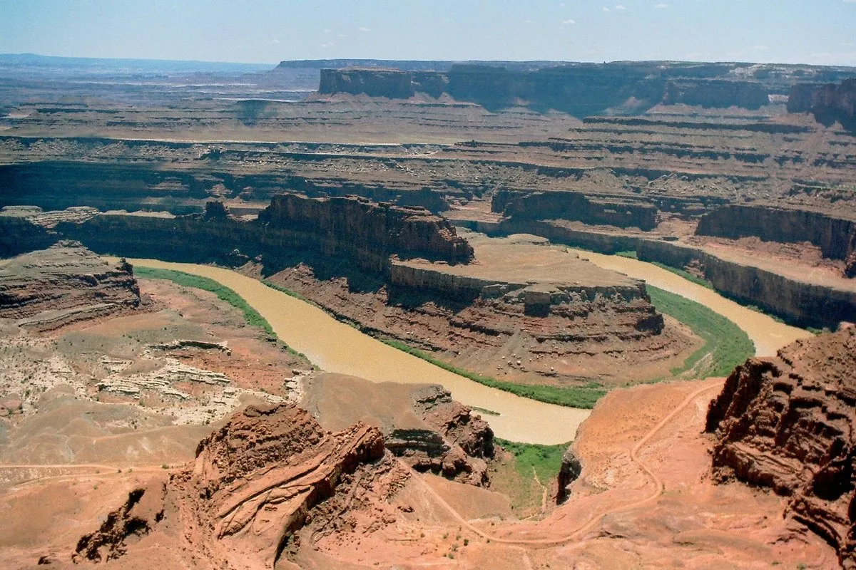 Panoramic view of the Colorado River winding through red rock canyons far below the mesa at Dead Horse Point, Utah
